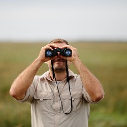 man looking through binoculars