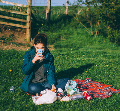 woman sitting on the grass having a picnic (image: Luke Porter on Unsplash)